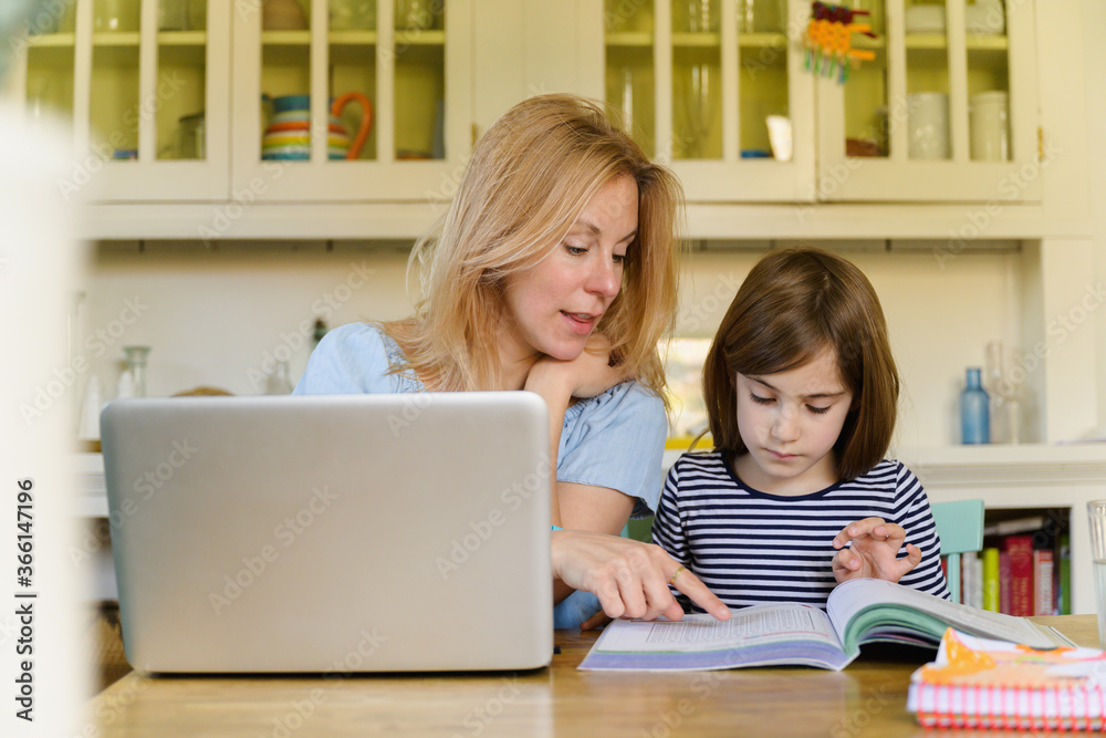 Mother helping daughter (6-7) doing homework Mother helping daughter (6-7) doing homework