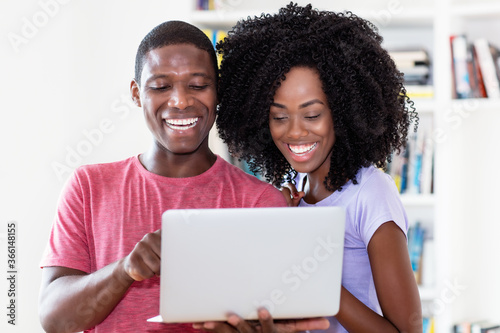 African american couple watching movie online with computer
