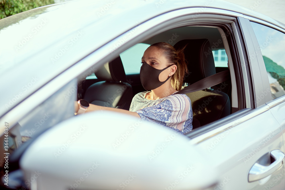 Woman with face mask driving car Woman with face mask driving car