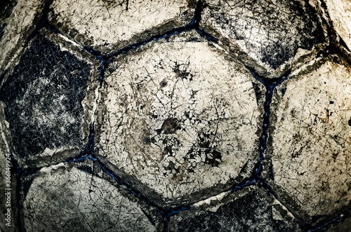 Used worn vintage soccer ball, close-up background with cracked grunge texture - cross processed