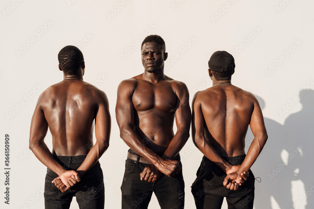 Three man crossing hands fists in protest, standing against white wall Three man crossing hands fists in protest, standing against white wall
