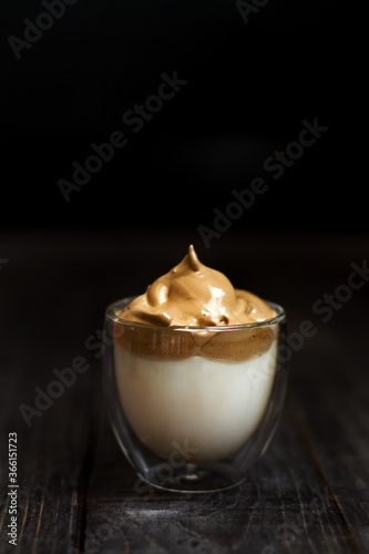 Glass cup with Iced Dalgona Coffee, a trendy  creamy whipped coffee