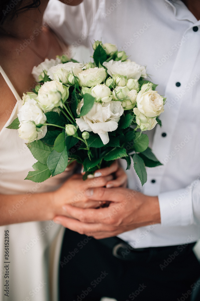 Newly married couple holding a wedding bouquet Newly married couple holding a wedding bouquet