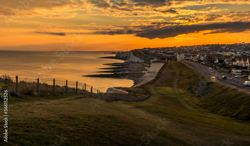 A view as the sun sinks low in the sky from Saltdean looking towards Brighton, UK in summer