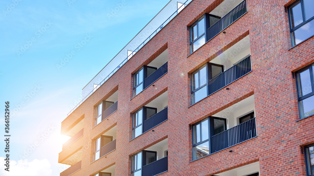 Modern apartment buildings on a sunny day with a blue sky. Facade of a modern apartment building. Glass surface with sunlight.