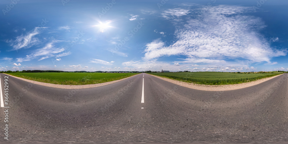 Fototapeta premium Full spherical seamless hdri panorama 360 degrees angle view on no traffic asphalt road among fields with cloudy sky in equirectangular projection, VR AR content