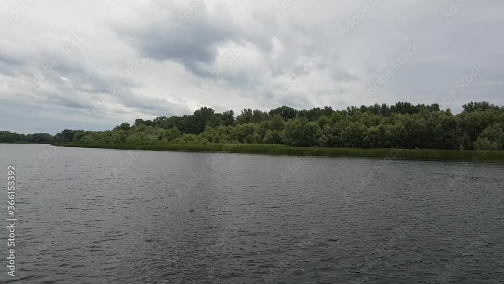 Time Lapse view of the river and the clouds running above it before the rain, dark blue and the forest opposite Time Lapse view of the river and the clouds running above it before the rain, dark blue and the forest opposite