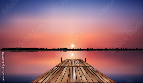 wooden bridge on the lake that goes into the pink sunset