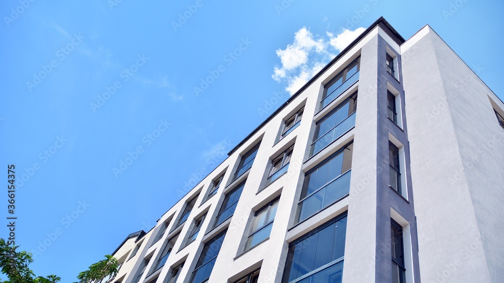 Modern apartment buildings on a sunny day with a blue sky. Facade of a modern apartment building. Glass surface with sunlight.