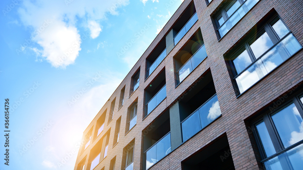 Modern apartment buildings on a sunny day with a blue sky. Facade of a modern apartment building. Glass surface with sunlight. Modern apartment buildings on a sunny day with a blue sky. Facade of a modern apartment building. Glass surface with sunlight.