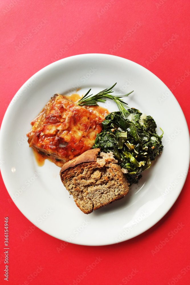 Lasagna dish with breag and vegetables and red background Lasagna dish with breag and vegetables and red background