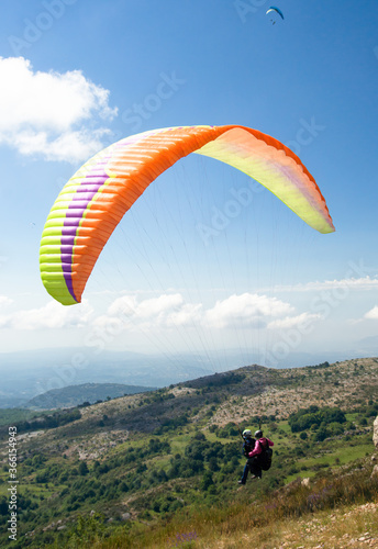 Two people taking off, paragliding post covid-19 with mask