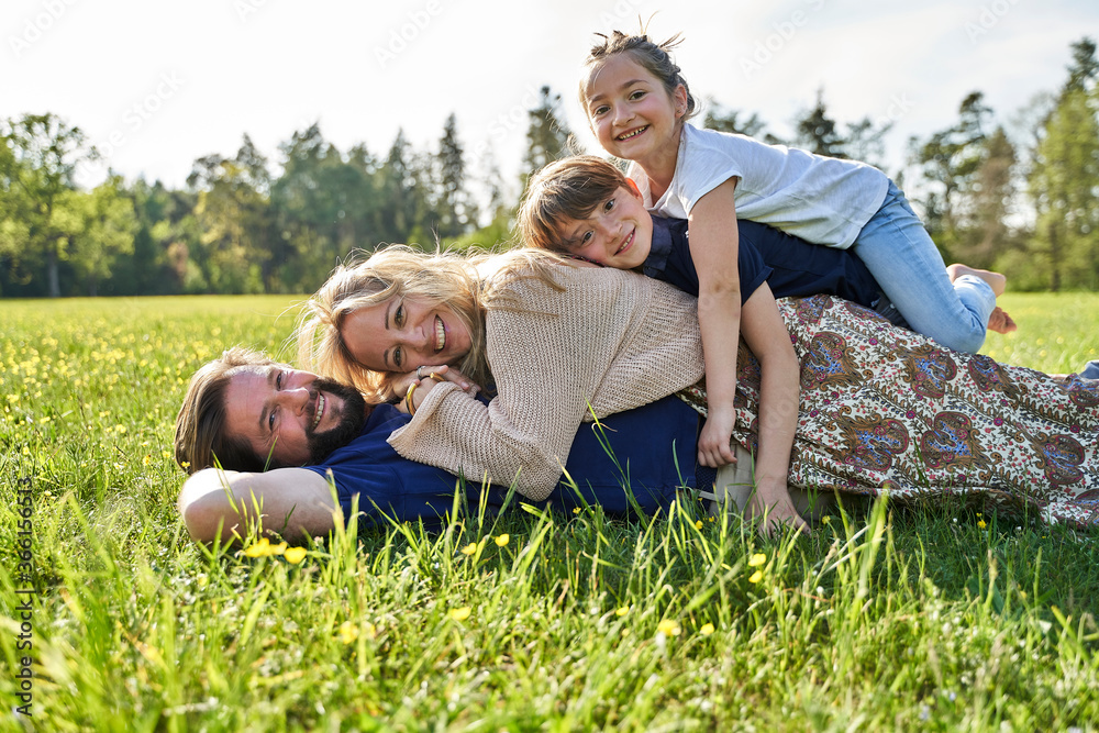 Happy family lying on grass during sunny day Happy family lying on grass during sunny day