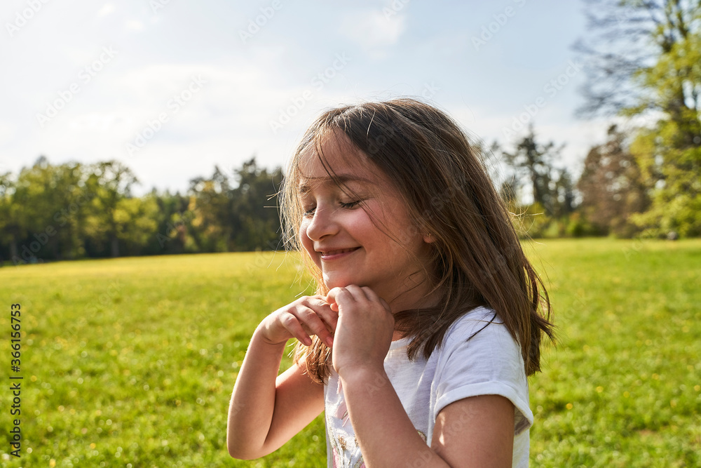 Cute girl with eyes closed and tousled hair against sky on sunny day Cute girl with eyes closed and tousled hair against sky on sunny day