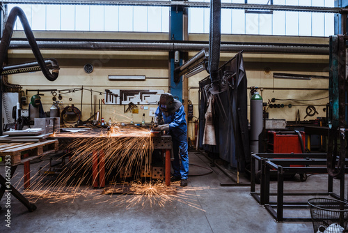 Welder welding metal in a factory