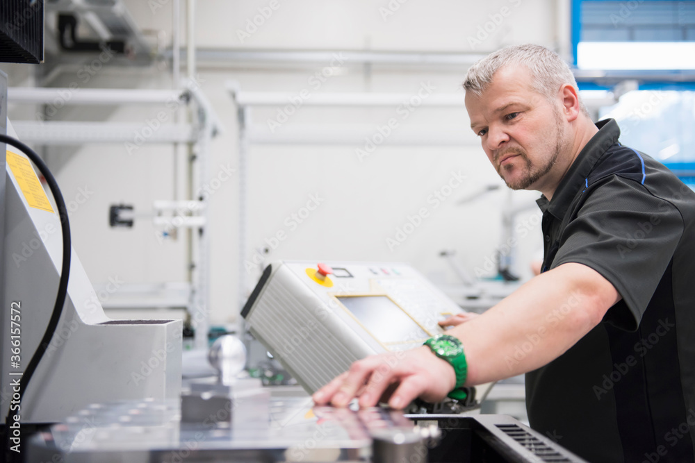 Man operating a machine in a factory Man operating a machine in a factory