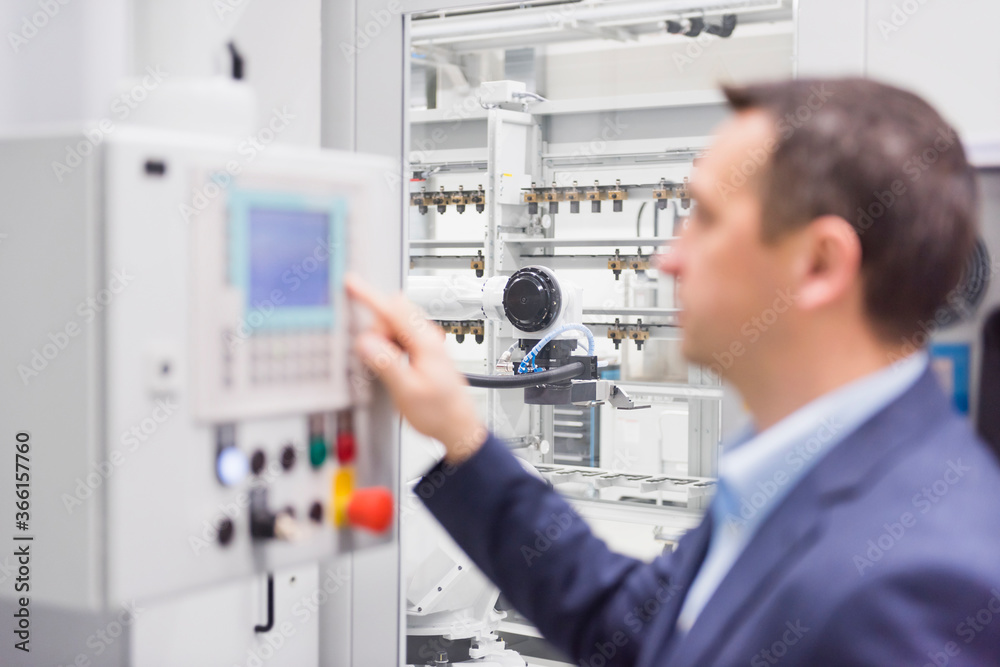 Businessman operating a machine in a factory Businessman operating a machine in a factory