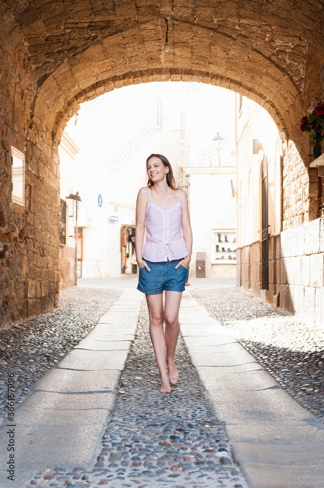 Happy tourist walking barefoot in the city, Sardinia, Italy Happy tourist walking barefoot in the city, Sardinia, Italy