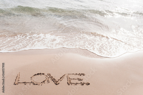 Word 'LOVE' scarified in wet sand at seafront