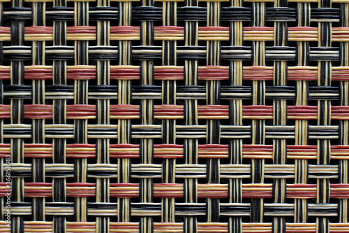 Plastic weft texture close-up in red, black and natural