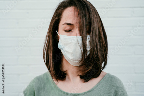 Portrait of woman with eyes closed wearing protective mask photo