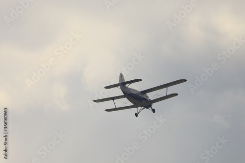 Classic old retro vintage airplane with a propeller in the sky on a background of clouds photo