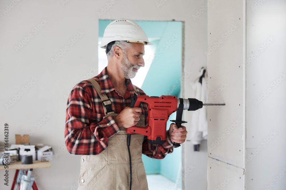Construction worker drilling at construction site