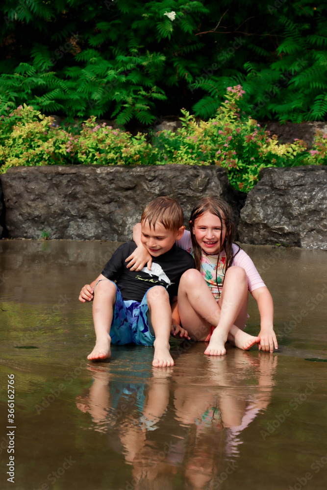 Fototapeta premium Frère et sœur complice dans les jeux d'eau pendant cette canicule!!