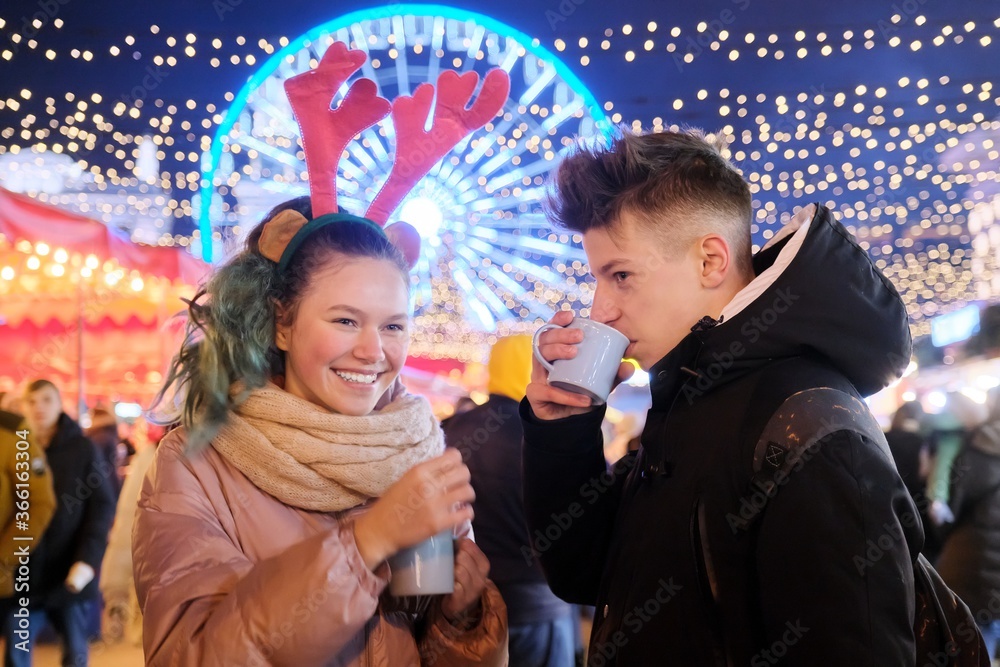 Young people, couple of teenagers having fun at Christmas market