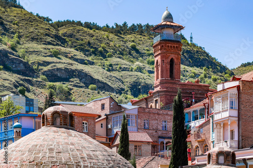 Jumah Mosque and residential buildings against mountain, Tbilisi, Georgia photo