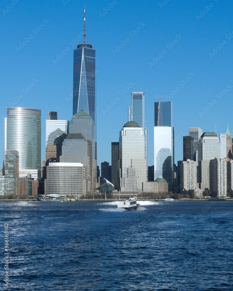 New York, NY / United States - April 20, 2018: Vertical image of lower Manhattan and World Trade Center with the Hudson River in the foreground.