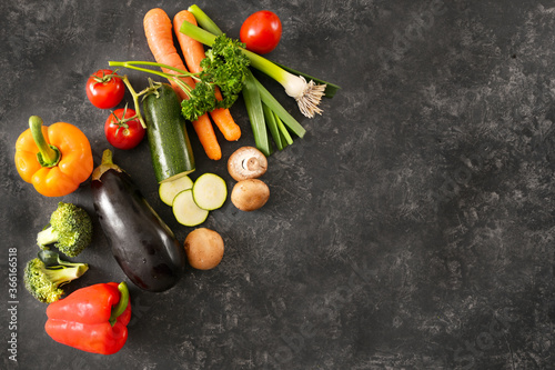 Organic vegetables fresh from the market for an healthy diet meal on a dark gray background with large copy space, cooking concept, high angle view from above