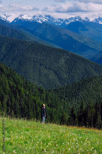 Girl hiker is soaking in the sun in flower fields in Olympic NP photo