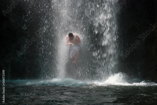 Man jumps through a waterfall in Costa Rica.