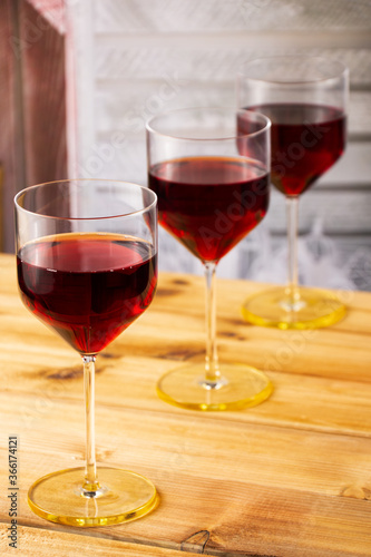 Three glasses of red wine on a wooden background. Shallow depth of field. Blurred background