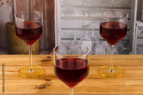 Three glasses of red wine on a wooden background. Shallow depth of field. Blurred background
