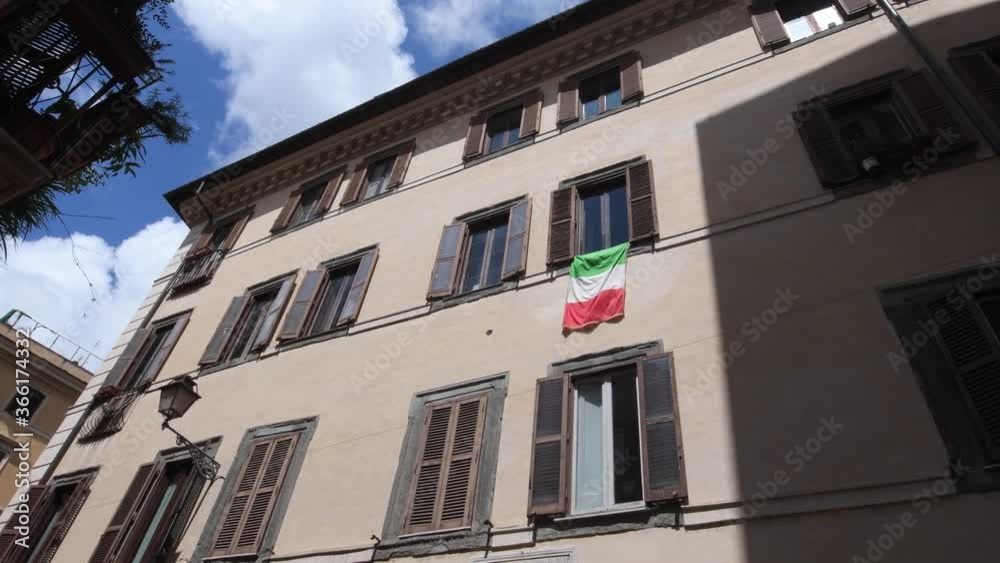 Italian flag hanging on a window in the historic center Italian flag hanging on a window in the historic center