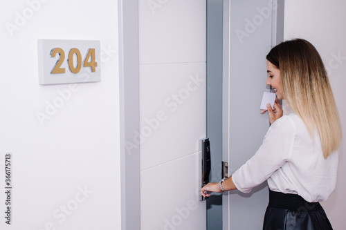 beautiful woman using her keycard to open up her hotel room 