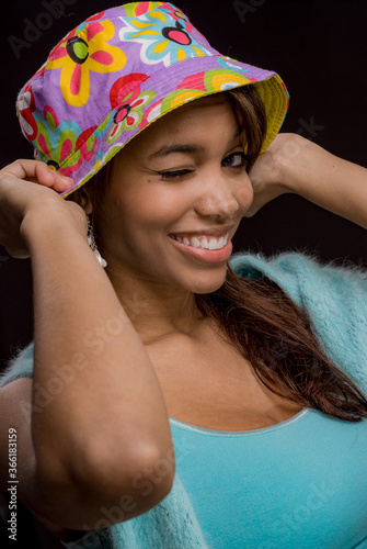 Pretty woman with a colorful hat winking