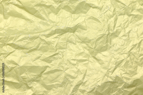 Golden crumpled paper background. Yellow crease paper texture. Copy space. Place for text