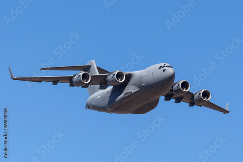 Large four engined military cargo airplane flying.