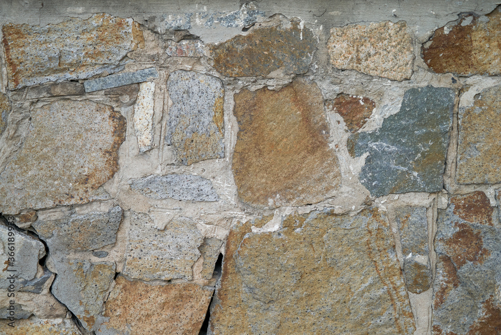 background of a solid stone wall made of cement, limestone and light rectangular bricks with an uneven surface of different colors and compositions background of a solid stone wall made of cement, limestone and light rectangular bricks with an uneven surface of different colors and compositions
