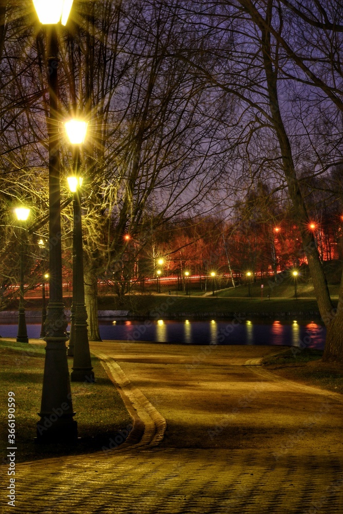 Burning lanterns on the night city street along the river