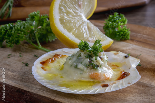 Baked Scallops with Cheese on a Wooden Cutting Board