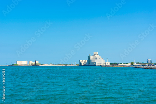 Fototapeta Naklejka Na Ścianę i Meble -  Museum of Islamic Art , Doha,Qatar in daylight exterior view with Arabic gulf in the foreground and clouds in the sky in the background