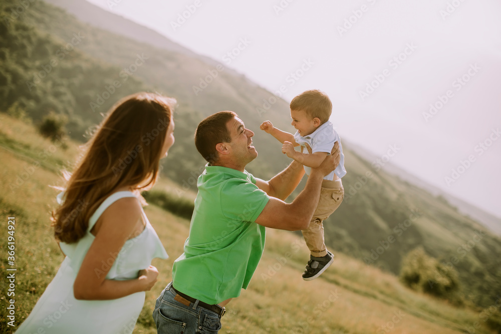 Fototapeta premium Young family having fun outdoors in the field