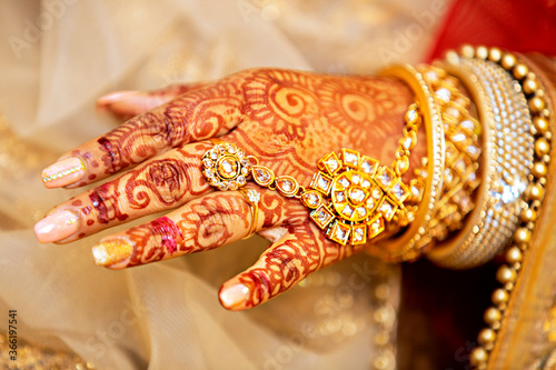 henna tattoo on hands with jewelries on wedding day.
