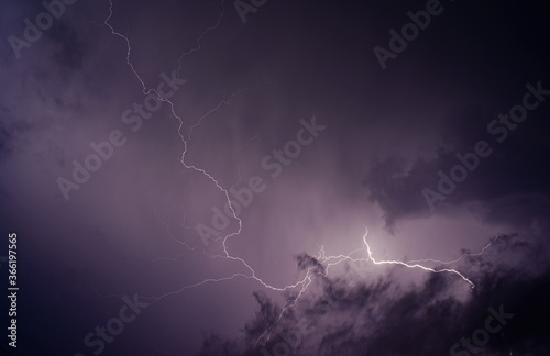 A bright flash of lightning against the dark purple night storm sky>