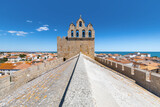 Symmetrical wide angle view of the rooftop of the french church of Saintes Maries de la Mer, against a blue summer sky