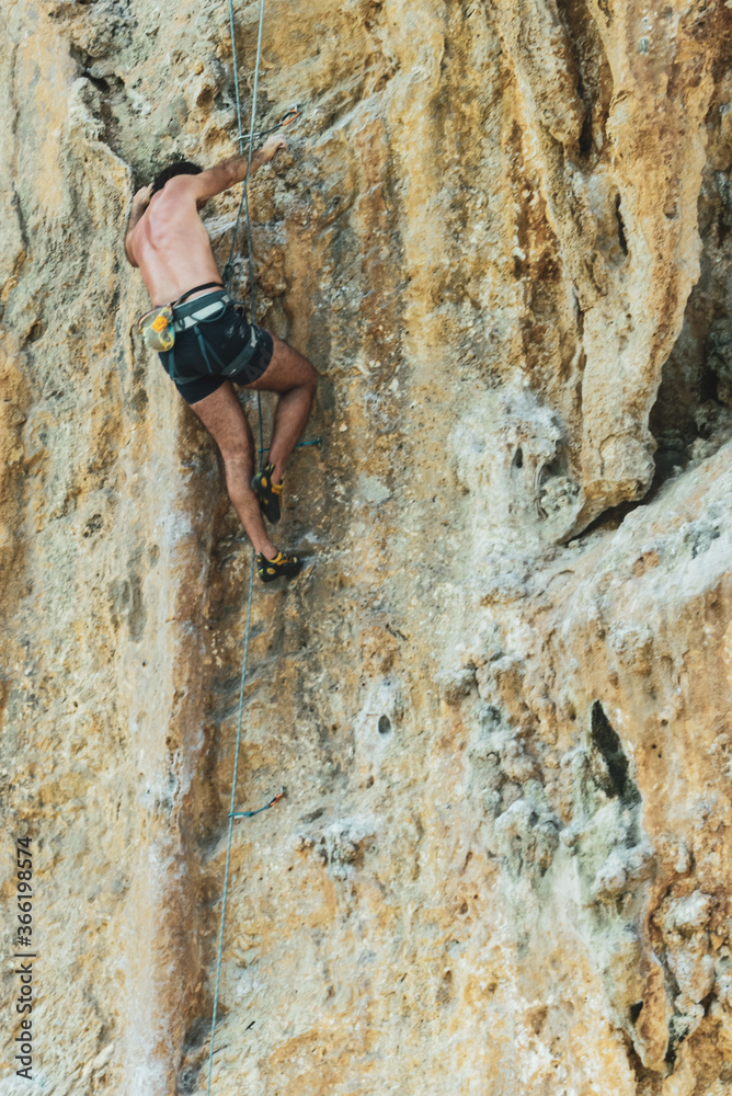 Fototapeta premium free climber in azione su una parete rocciosa a picco sul mare